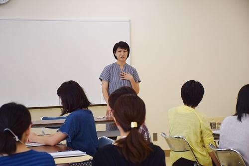 数人の女性参加者の前で一人の女性が話している写真
