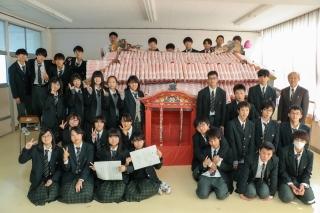段ボール首里城の周りに並んで記念撮影する児童たちの写真