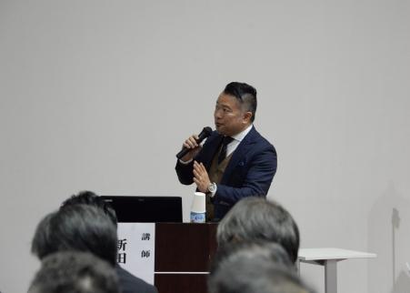 マイクを手に話しをする男性の写真