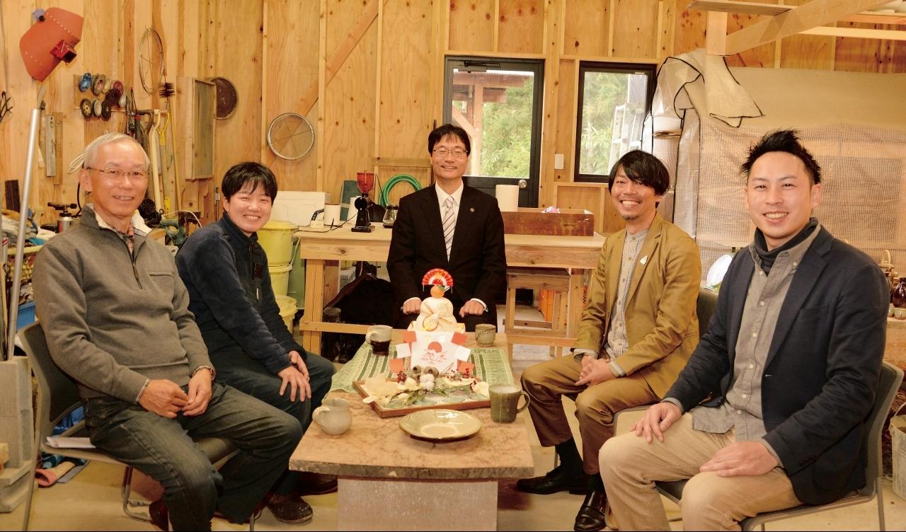 工房の中でカメラに向かって笑顔を見せる5名の座談会参加者たちの写真