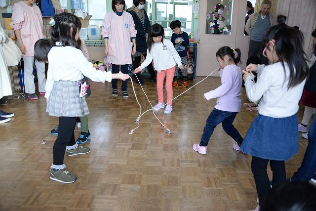 部屋の中コマを回している3人の女の子たちの写真