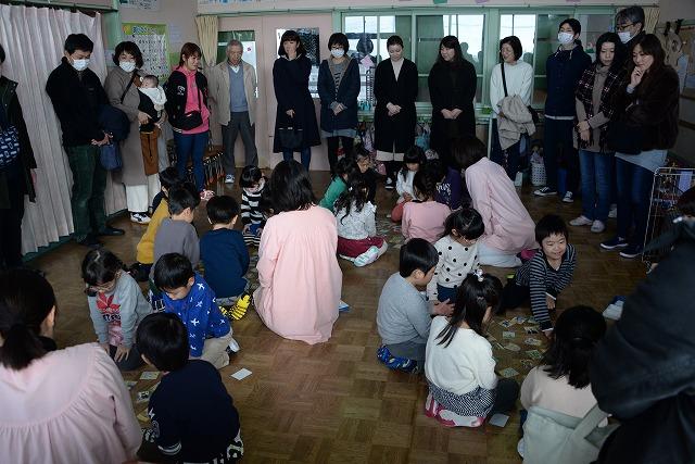 グループに別れてつばめっ子かるたをして盛り上がっている様子とそれを見守る保護者たちの写真