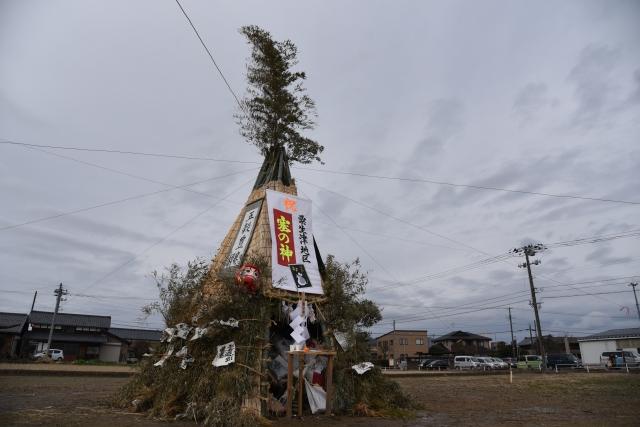 保育園のグランドに建てられた「塞の神」のお焚き上げで使う藁で作られた木の塔の写真