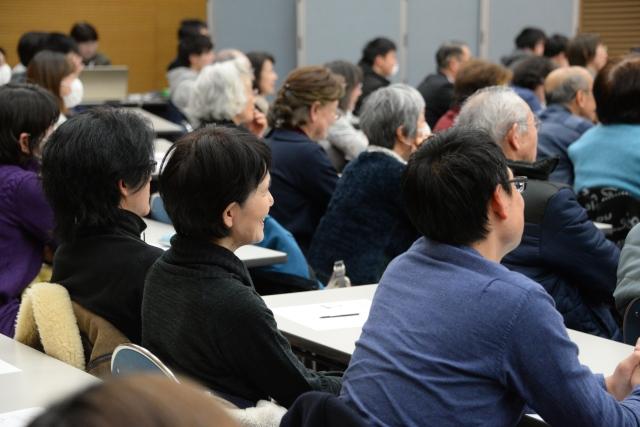 講演で笑顔で話を聞いている参加者たちの写真