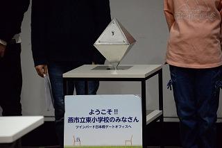 正方形のテーブルの上に立っている銀色の八方体のオブジェクトの写真