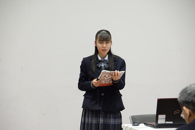 書類を手に、真っ直ぐ前を見て発表をしている女子生徒の写真