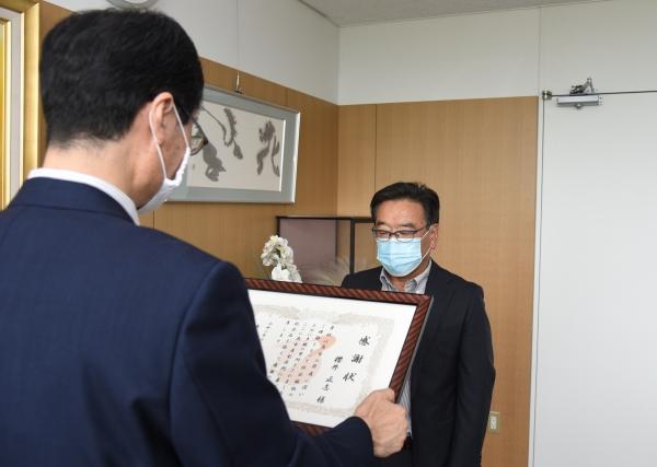感謝状を読み上げている男性と、向かい合って聞いている男性の写真
