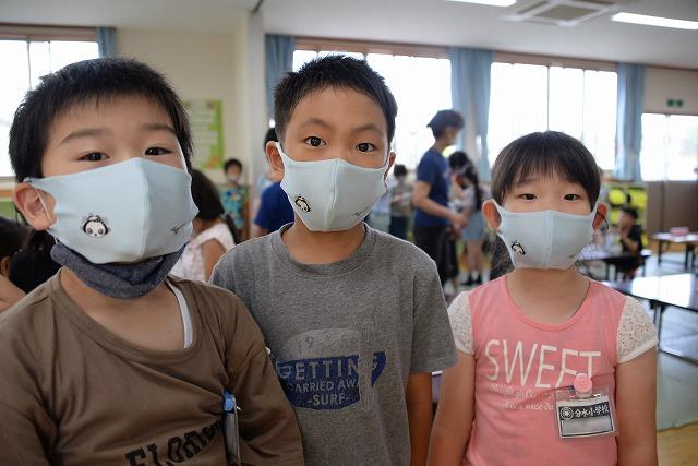 配られたマスクを付けて横に並ぶ3人の男女の子供達の写真