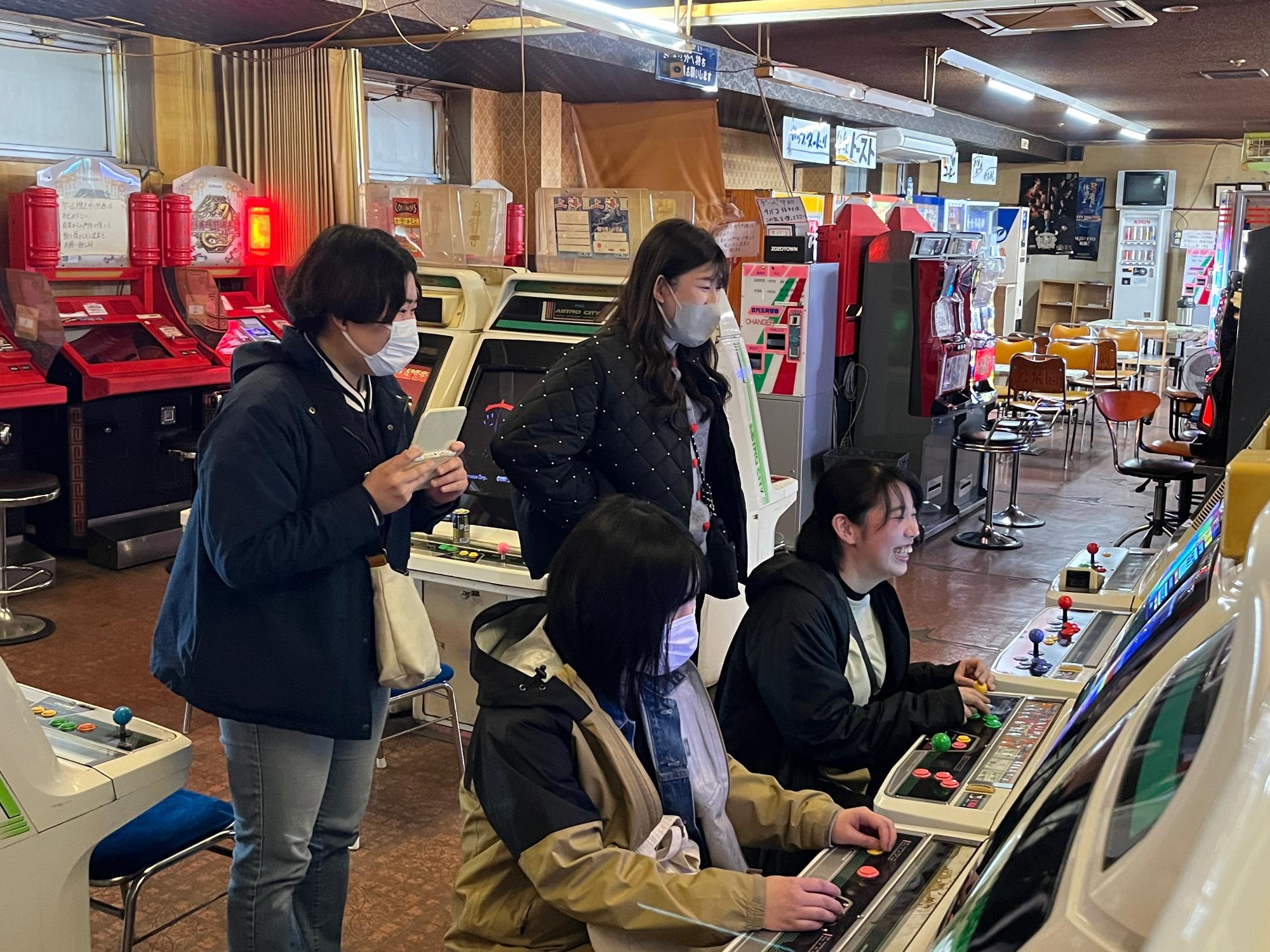 昔ながらのゲームにはしゃぐ若者たち