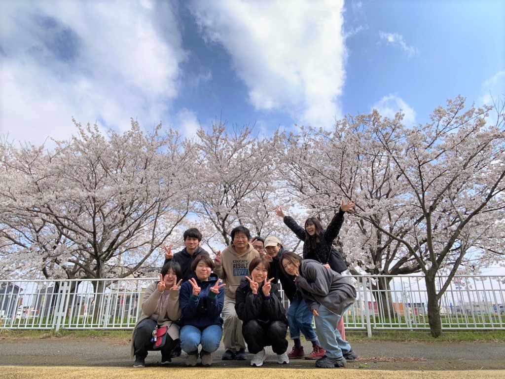 お花見会桜並木をバックに集合写真