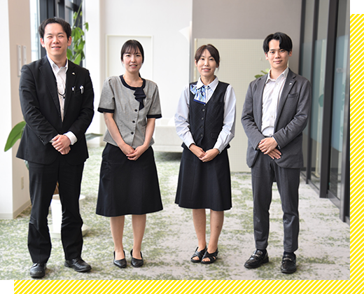 オフィス服を着た男女4名が横並びになっている画像