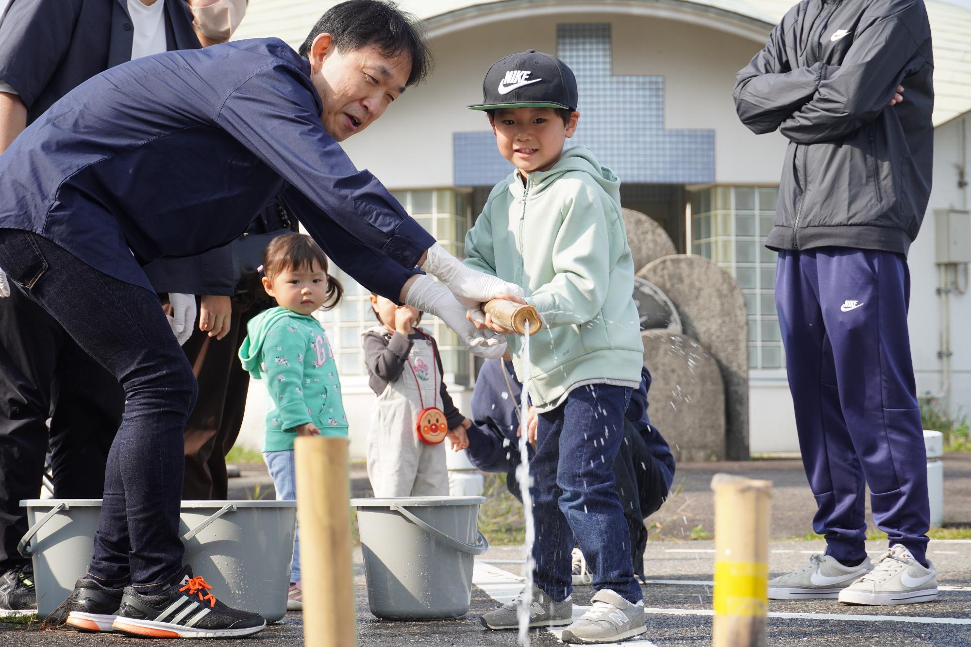 竹水鉄砲で遊ぶ子ども達