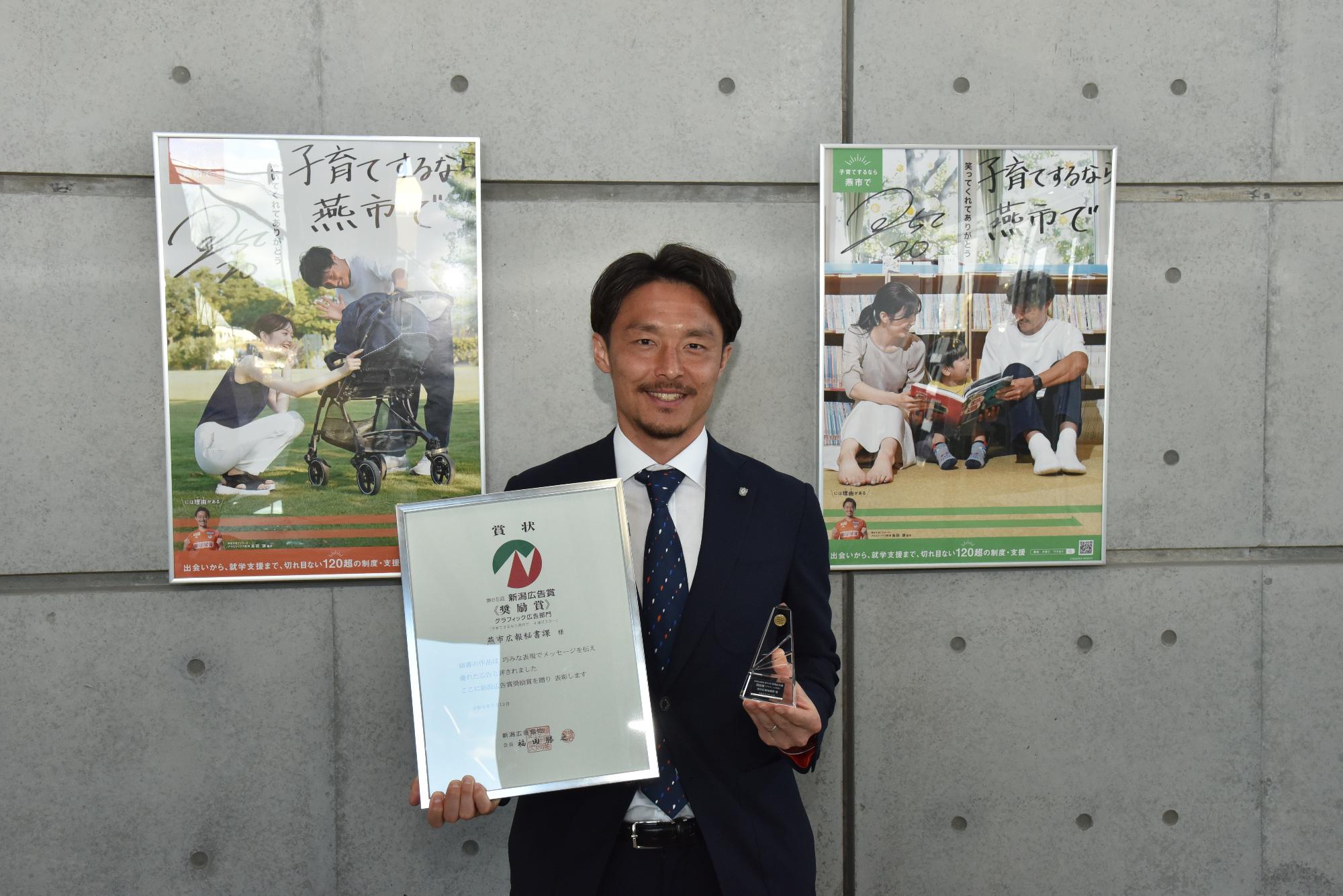 新潟広告賞で奨励賞を受賞したポスターの前で写る島田選手