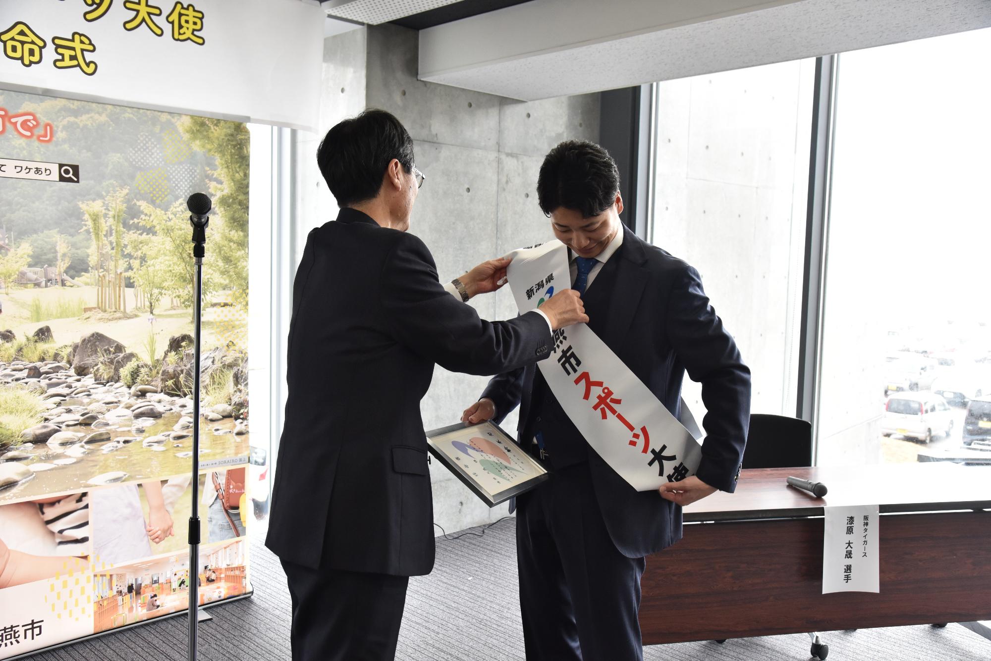 タスキを掛ける漆原選手