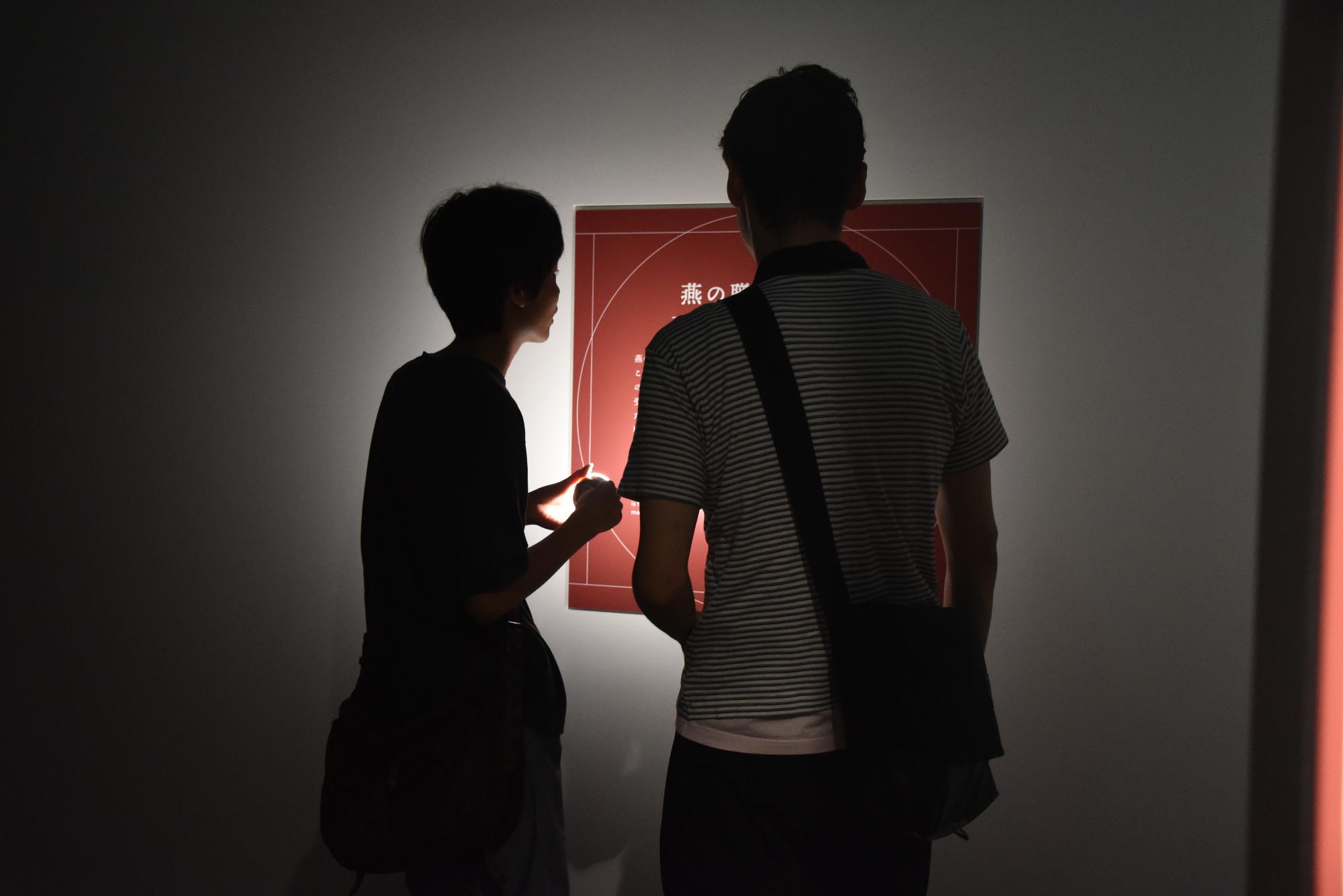ライトを照らしながら作品を見ている様子