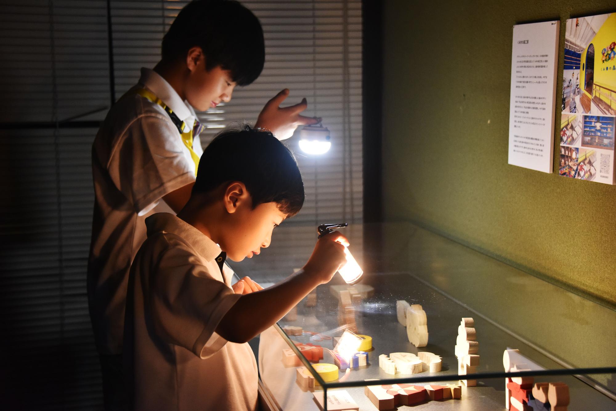 ライトを照らしながら作品を見ている様子