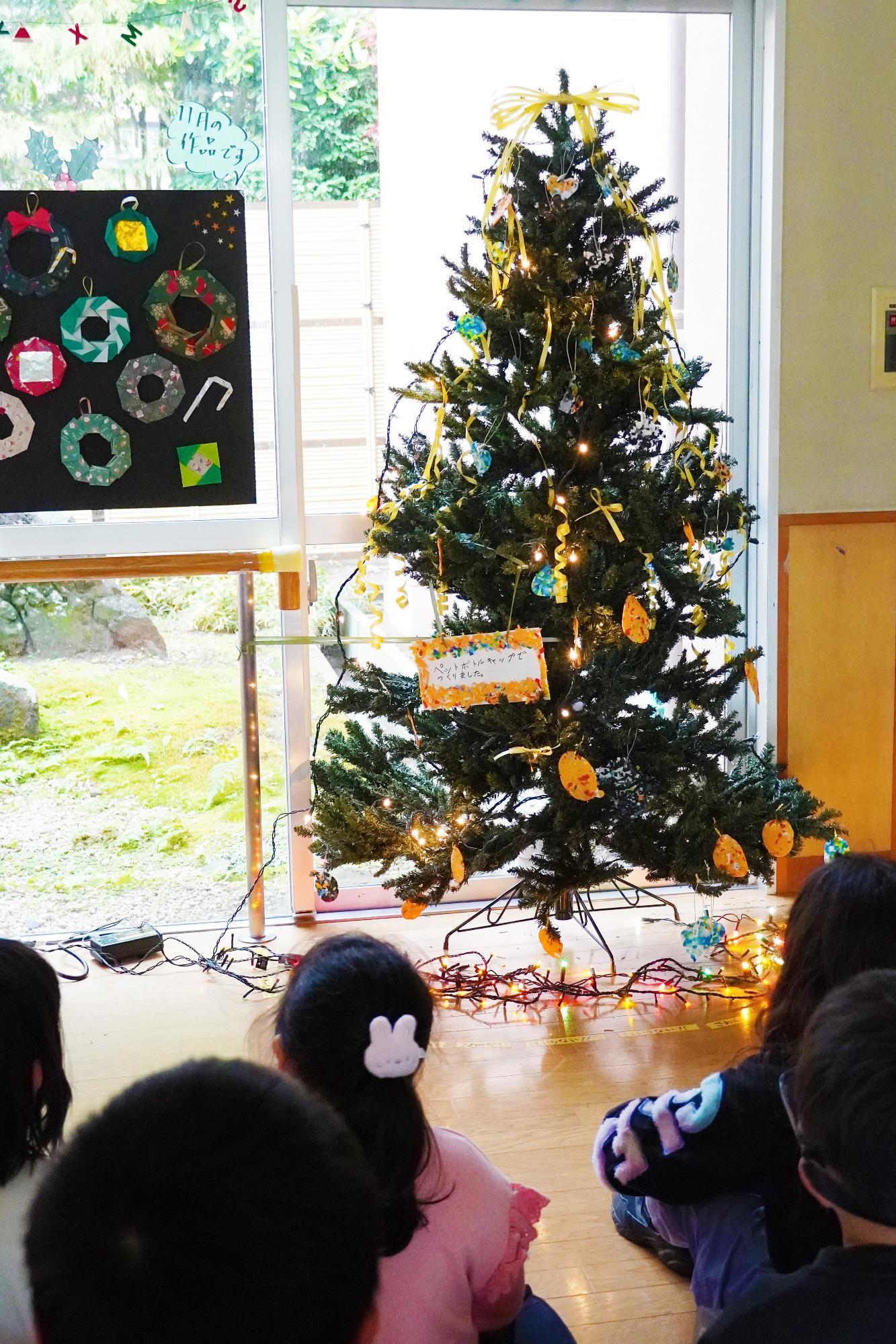 飾り付けしたツリーをみるこども