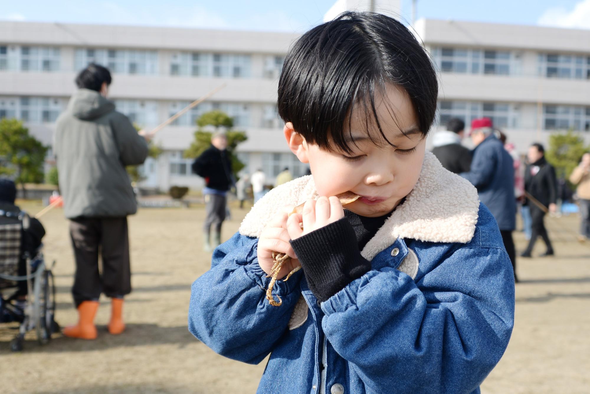 炙ったスルメを食べている様子