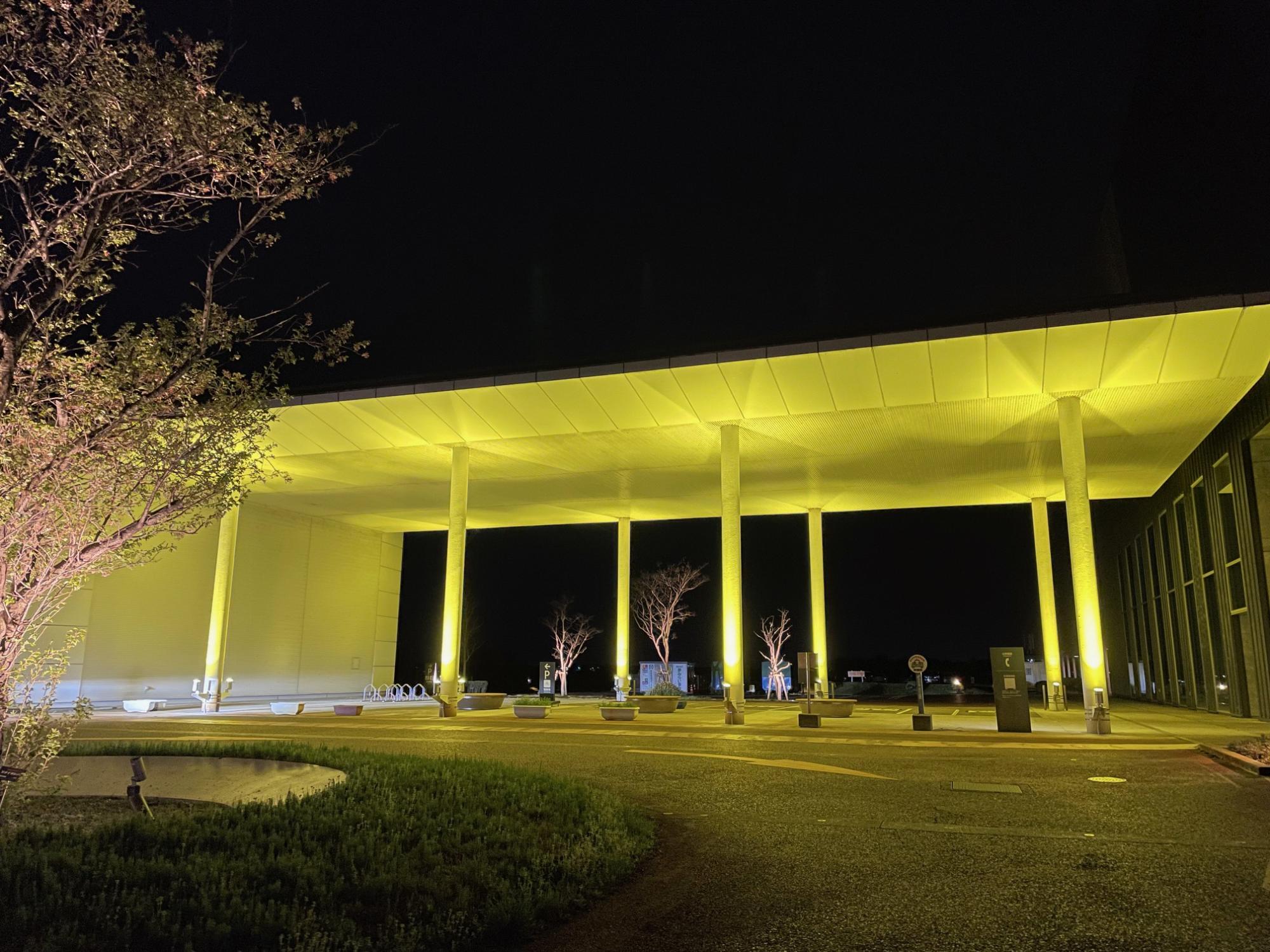 燕市役所がイエローにライトアップしている様子