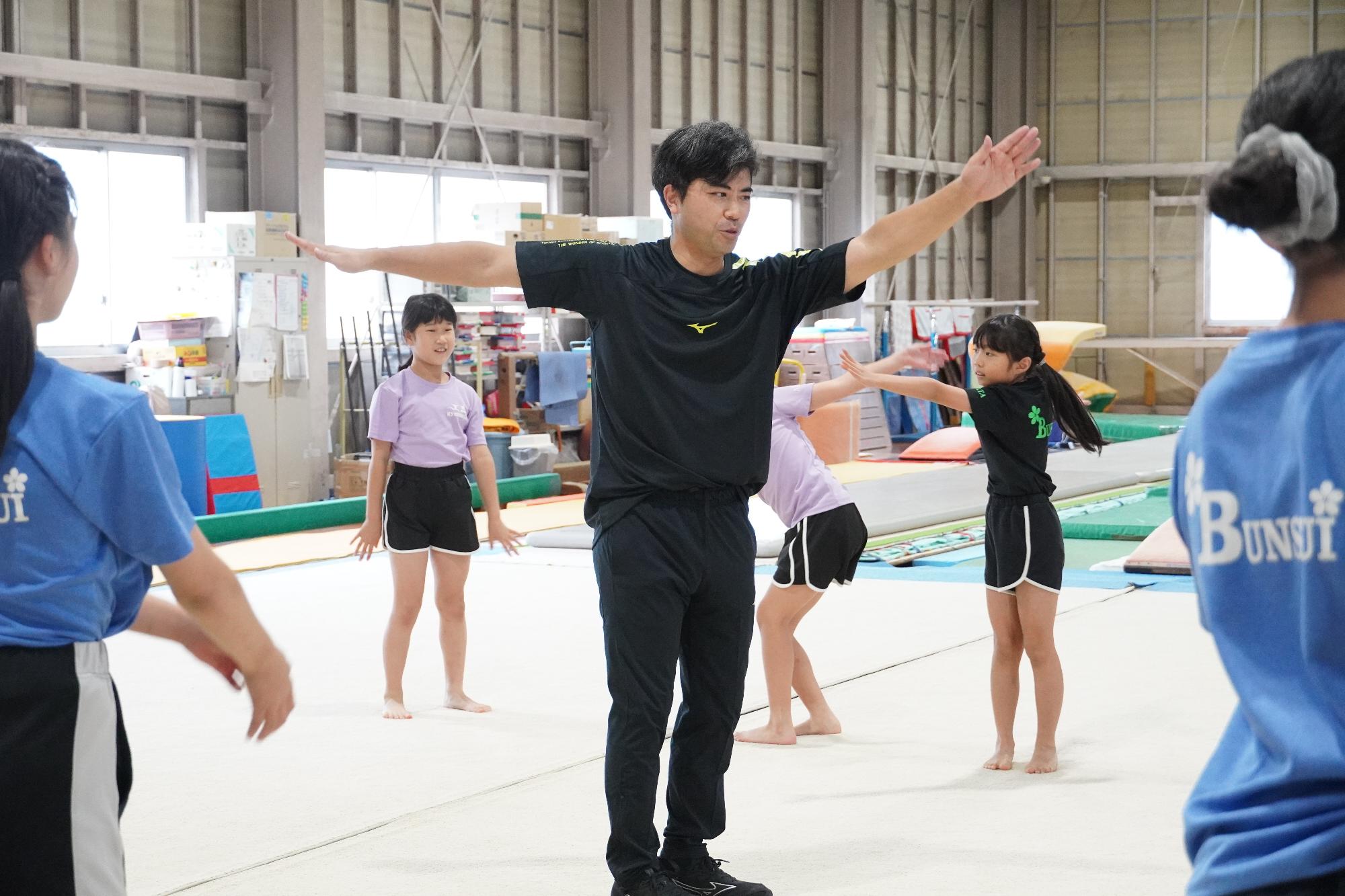 講師の塚原さんと一緒に準備運動をする様子