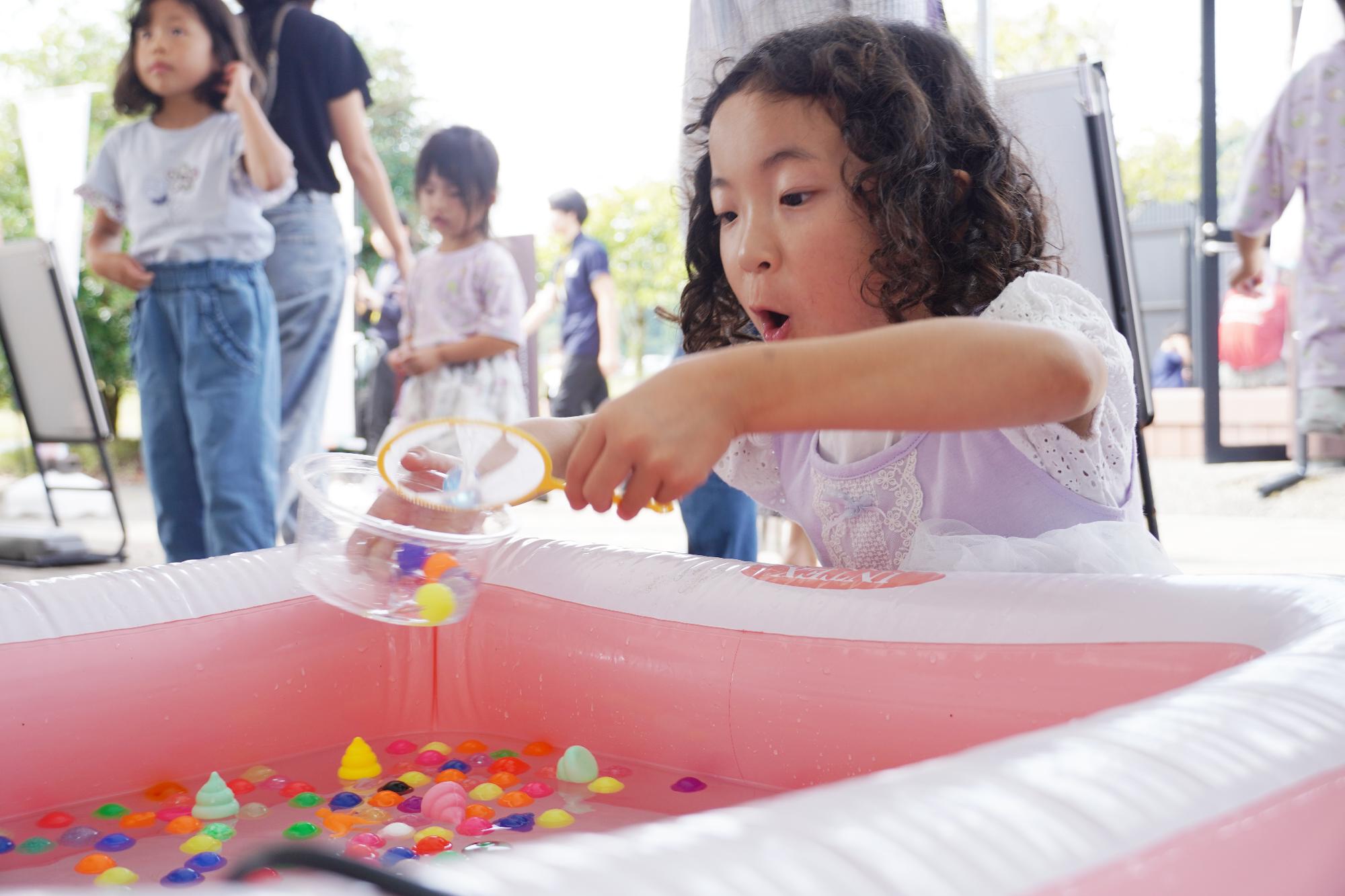 ボールすくいをする子ども