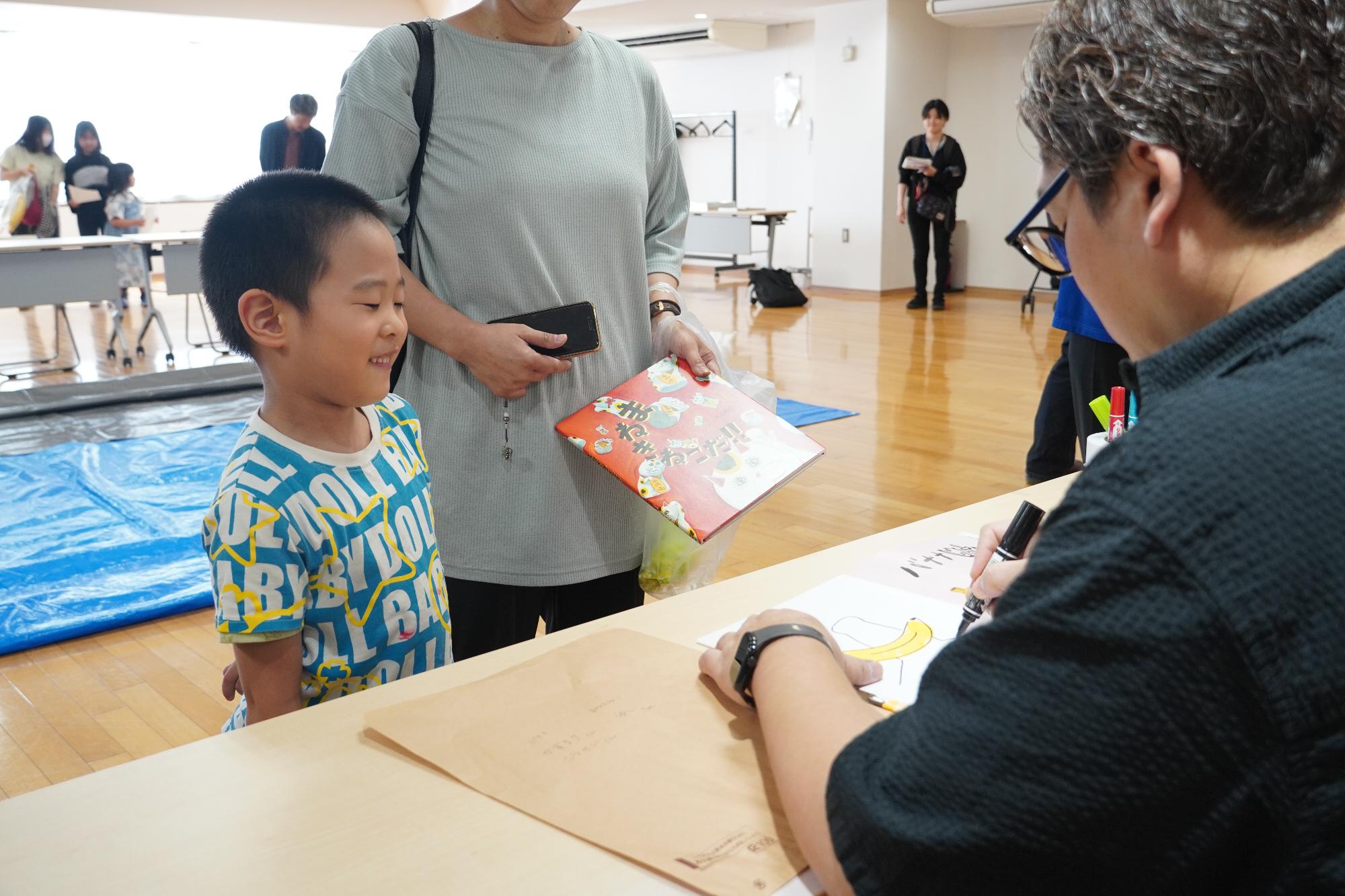 高畠さんからサインをもらう子ども