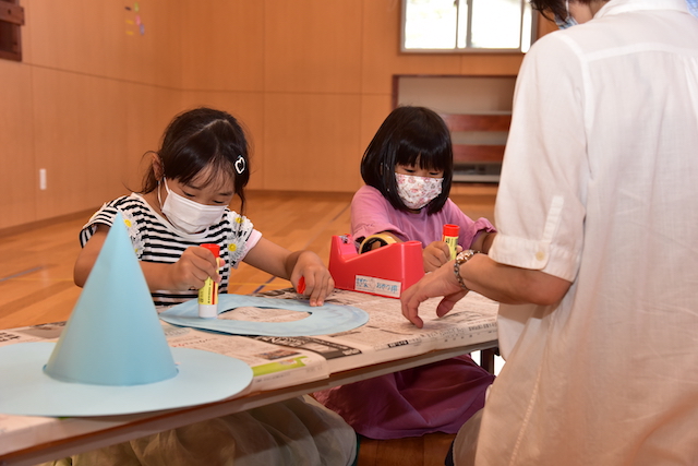 魔女の帽子を製作する子どもたちの写真