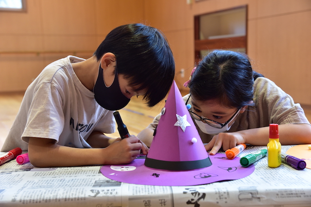 魔女の帽子を製作する子どもたちの写真