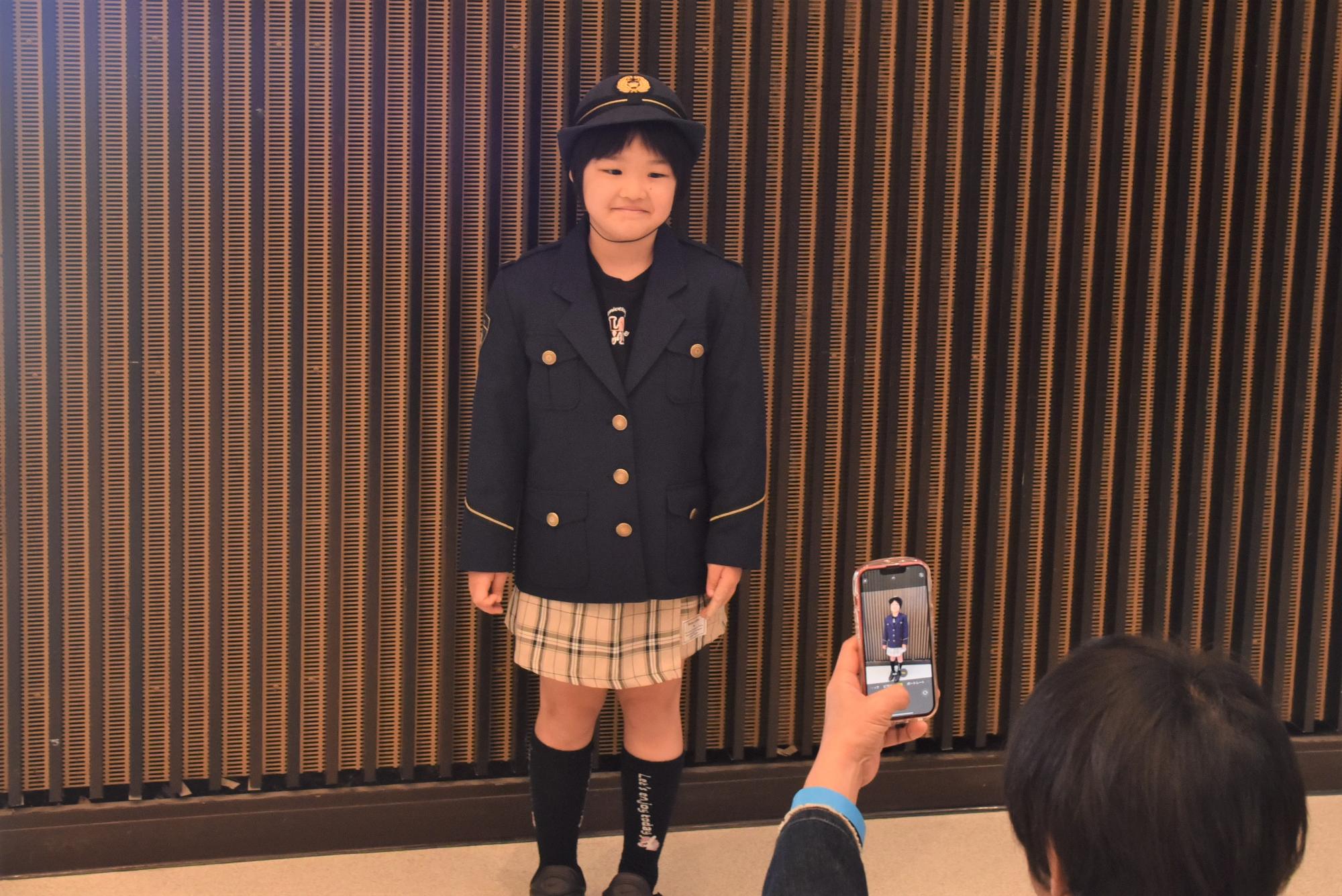 警察官の制服を着て記念撮影するこども