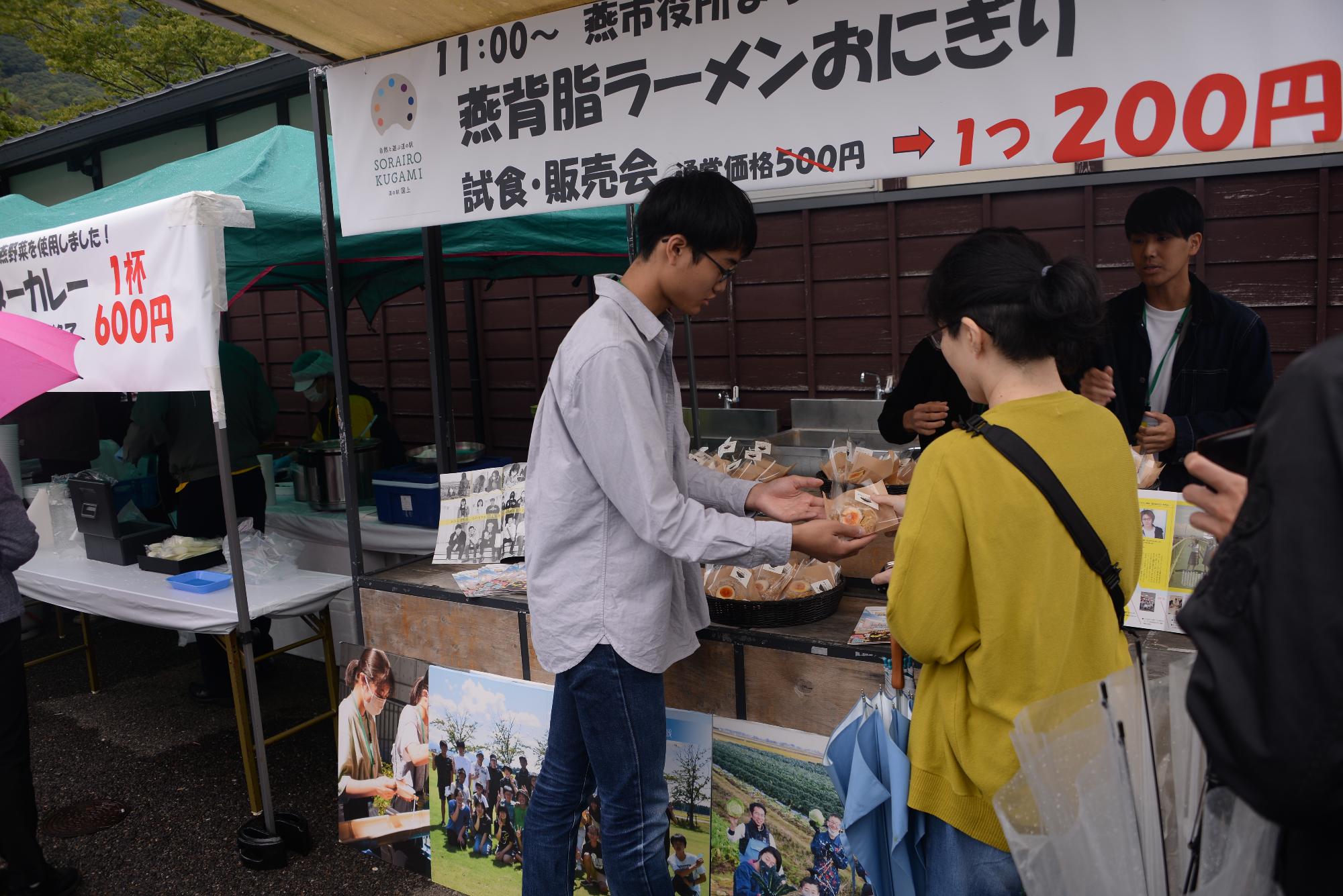 燕背脂ラーメンおにぎりを販売するまちあそび部メンバーの様子