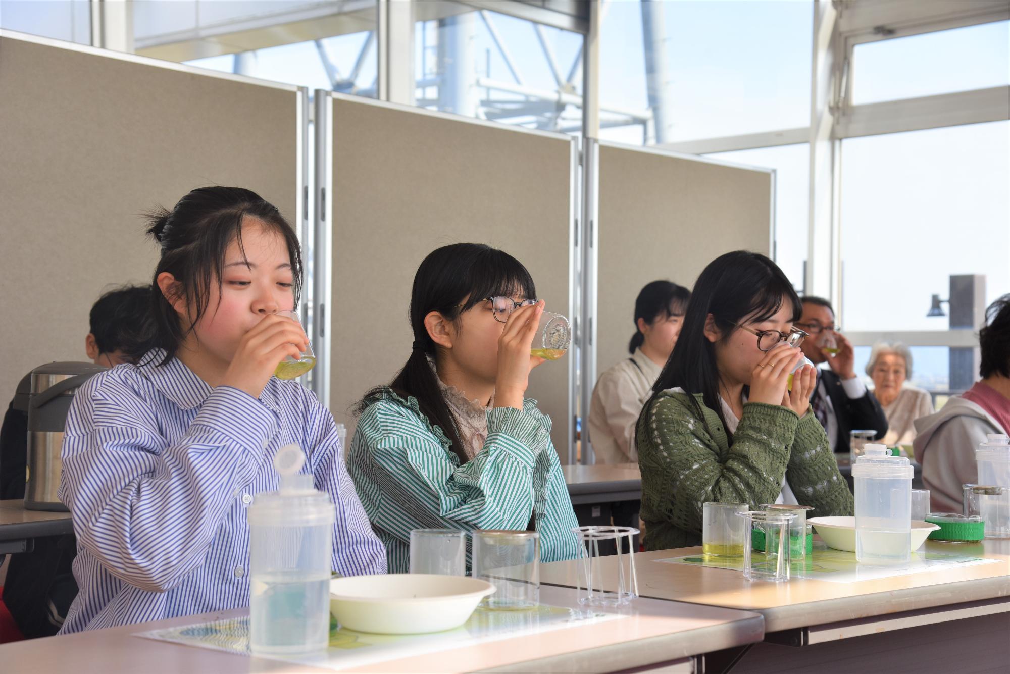 お茶を飲んでいる3人の高校生