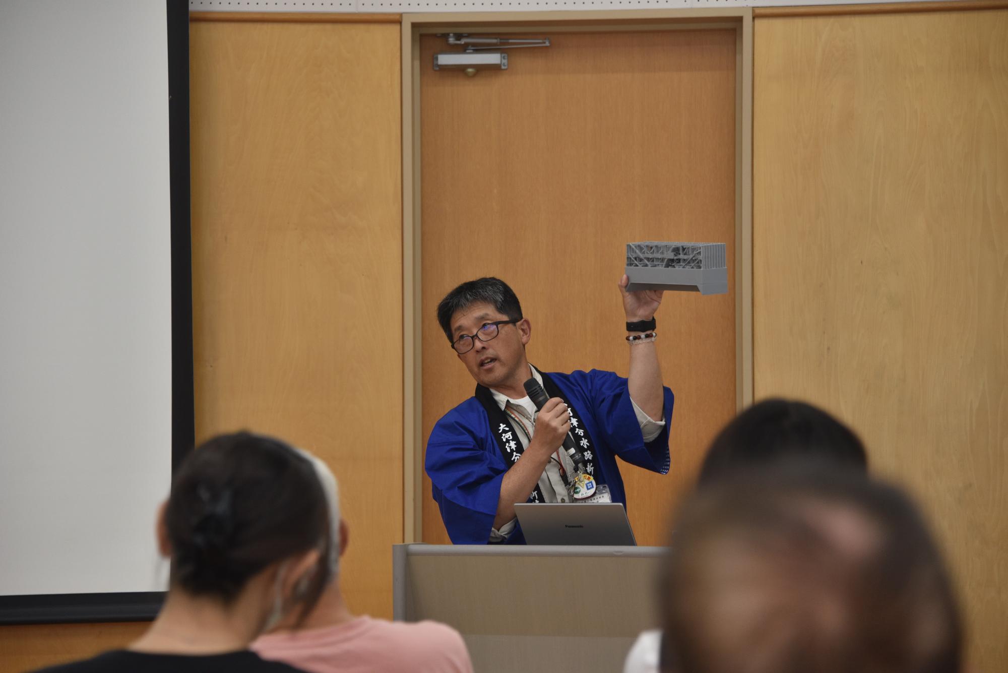 模型を使い説明する工事事務所の萩野さん