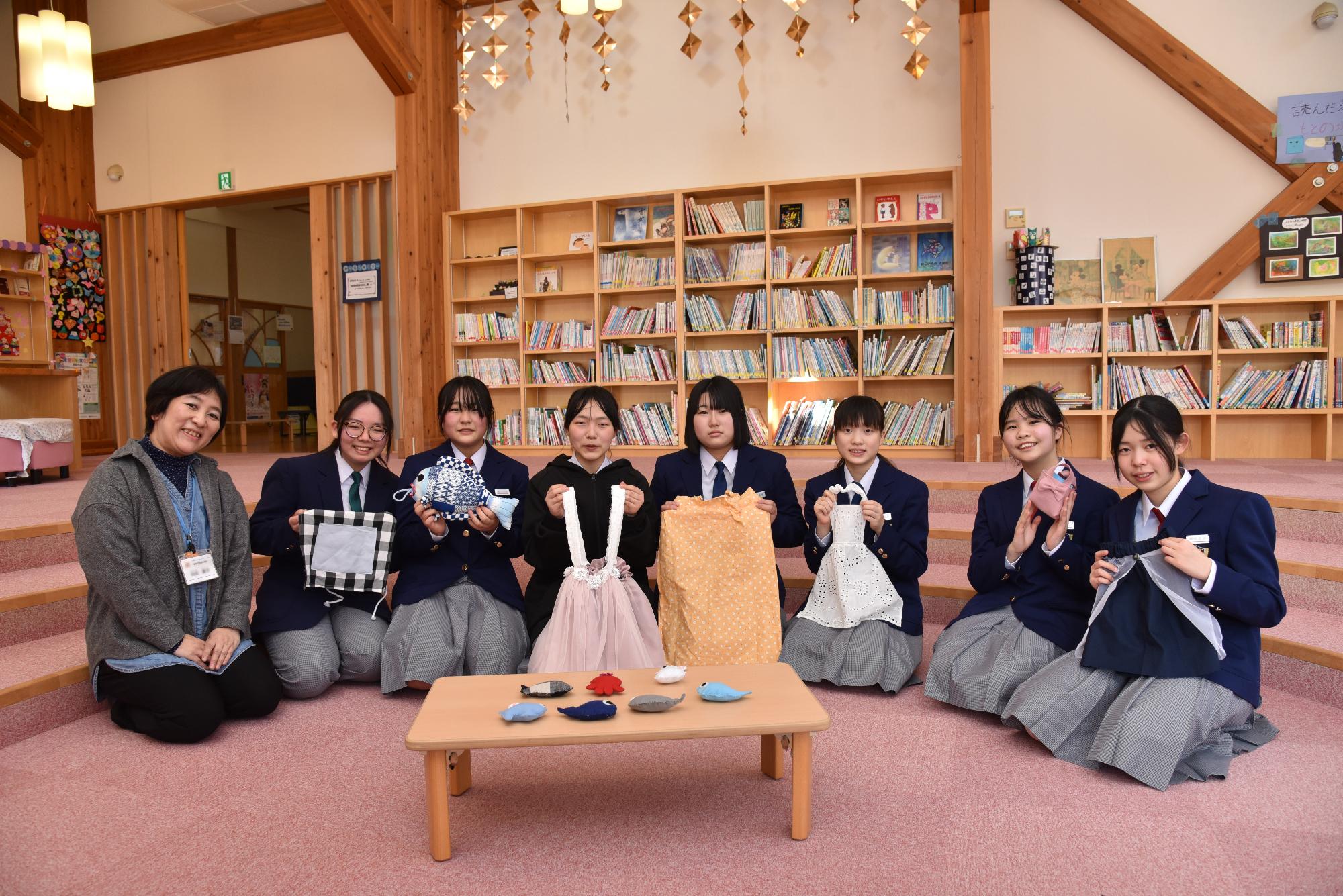 衣装、おもちゃを寄付する吉田中学校家庭部の生徒と先生