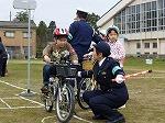 自転車に乗っている子どもに、目線を合わせて交通ルールを教えている警察官の写真