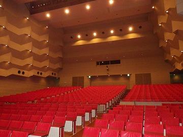 赤い座席が並ぶ文化館大ホール内の写真