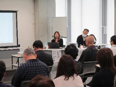 平栗講師がマイクを持ち、講演している様子