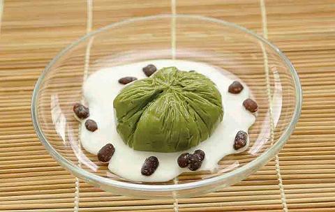緑色の茶巾デザートが白いクリームの上にキレイに盛り付けられている「もちもちミルク茶巾デザート」の写真