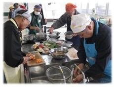 参加者たちが、食材を切ったり洗い物をしたりなど、分担して調理をしている写真