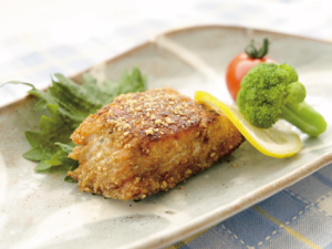 スライスレモンと付け合わせの野菜が添えられた「鮭のごま焼き」の写真