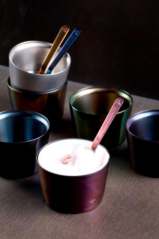 様々な色のカップと赤いカップにアイスクリームが入っていてスプーンが差してある写真