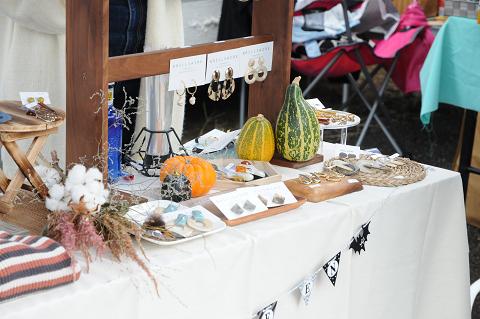 白い布がかかったテーブルの上にカボチャなどの野菜が並べられ展示されている写真