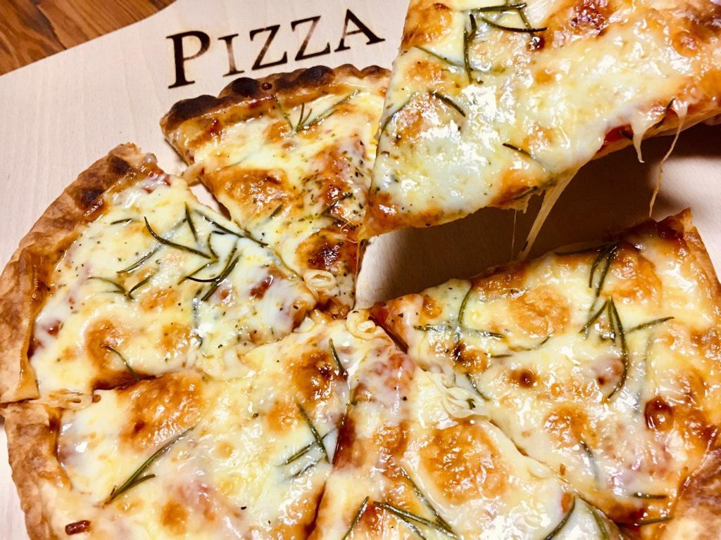 ピザが6個に切られていて、そのうちの1個を持ち上げてチーズが美味しそうに伸びている写真