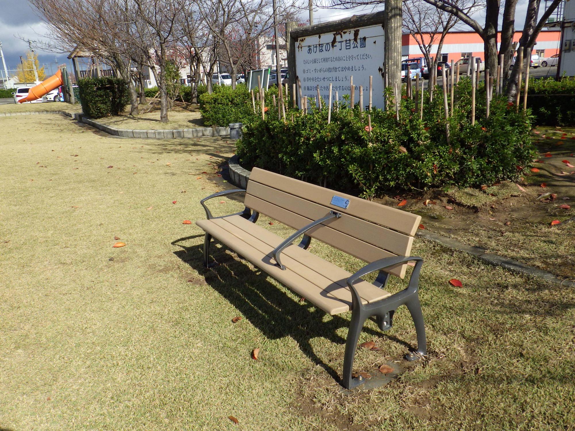 芝生のある公園に設置されたベンチの写真