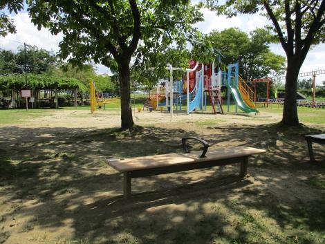 木漏れ日の差す燕市交通公園内に設置されたベンチの写真