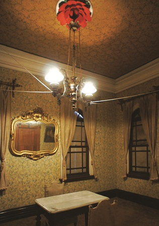 模様のある壁に飾られた鏡が特徴の西洋風の部屋の写真