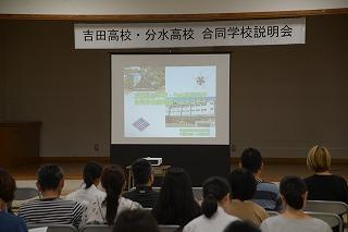 講堂で合同学校説明会のスライドを見ている参加者たちの写真