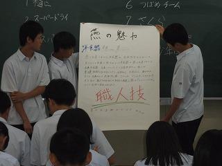 「燕の魅力 職人技」と書かれた模造紙を掲げ、説明をしている3人の男子学生の写真