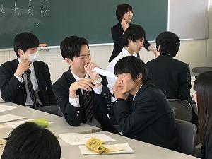 筒を口に当てて隣に話しかけている男子生徒と、笑って聞いている男子生徒の写真