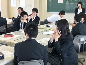 筒を使って話しかけようとしている女子生徒と、隣に座っている男子生徒の写真