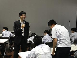 笑顔で話しかけている市長と、立って頭を下げている男子生徒の写真